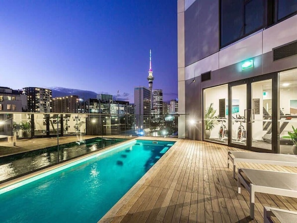 Une piscine sur le toit offrant une vue panoramique sur la ville, avec notamment une tour imposante.