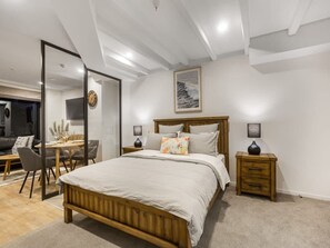 A bedroom with a bed, bedside tables, a desk, and a chair.