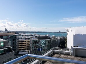 A cityscape with buildings, a waterfront, and a clear sky. - CBD Escape with Pool Near Sky Tower by Zodiak (Auckland)