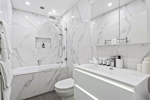 Bathtub, hair dryer, towels, shampoo