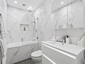 Bathtub, hair dryer, towels, shampoo - Sleek Modern Pad next to Spark Arena: Zodiak Stays (Auckland)