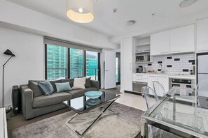 Un appartement moderne comprenant un espace de vie, une cuisine et un coin repas.