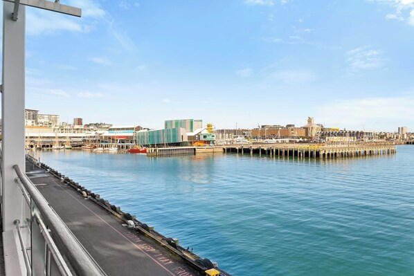 Vista al agua con un muelle, edificios y cielo despejado.