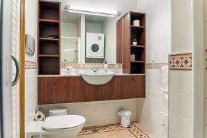 A bathroom with a toilet, sink, and shower area. - Relaxing Sea Wharf View Apartment by Zodiak Stays (Auckland)