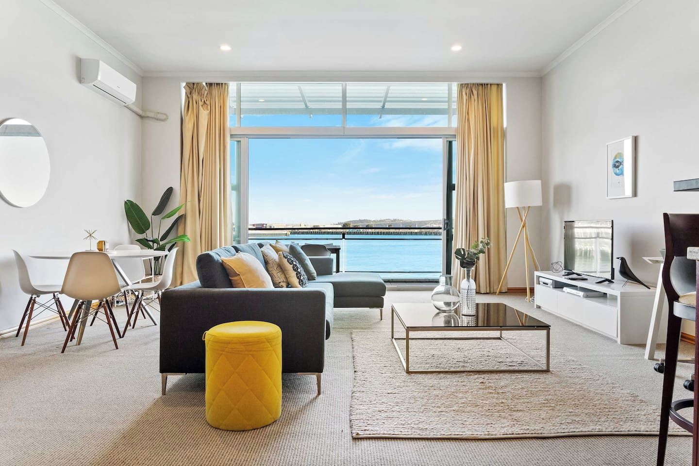 A modern living room with a sofa, coffee table, and dining area.