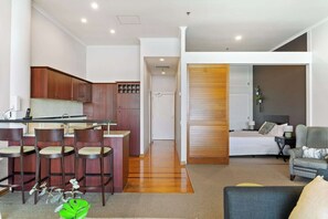 A modern apartment with a kitchen, dining area, and living room. - Relaxing Sea Wharf View Apartment by Zodiak Stays (Auckland)