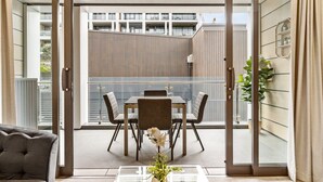 Un interior moderno con comedor, sofá y vista a un edificio.