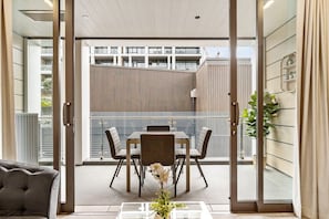 Ein modernes Interieur mit Essbereich, einer Couch und Blick auf ein Gebäude.