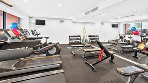 A modern gym with treadmills, weight machines, and free weights. - Gorgeous 2BR in Wynyard Quarter by Zodiak Stays (Auckland)