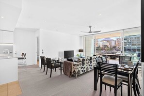 Una sala moderna con un sofá, sillas, una mesa de comedor y un televisor.