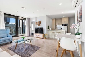 Un appartement moderne comprenant un espace de vie, un coin repas et une cuisine.