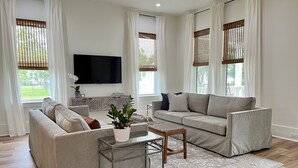 Una sala de estar moderna con dos sofás, una mesa de centro y un televisor.