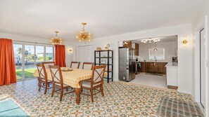 Une cuisine moderne équipée d’un réfrigérateur, d’une cuisinière et d’un coin repas avec une table et des chaises.