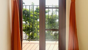Quarto com porta de vidro deslizante que dá para uma varanda.