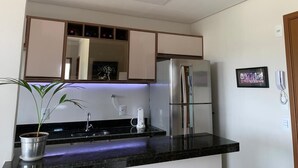 Une cuisine moderne avec un réfrigérateur en acier inoxydable, un évier et une plante en pot.