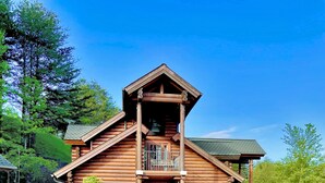 A log cabin with a pool and a patio area. - Spring Special! Hot Tub, Pools, Smart TV's, Wi-Fi, Arcade, Parkway! (Pigeon Forge)