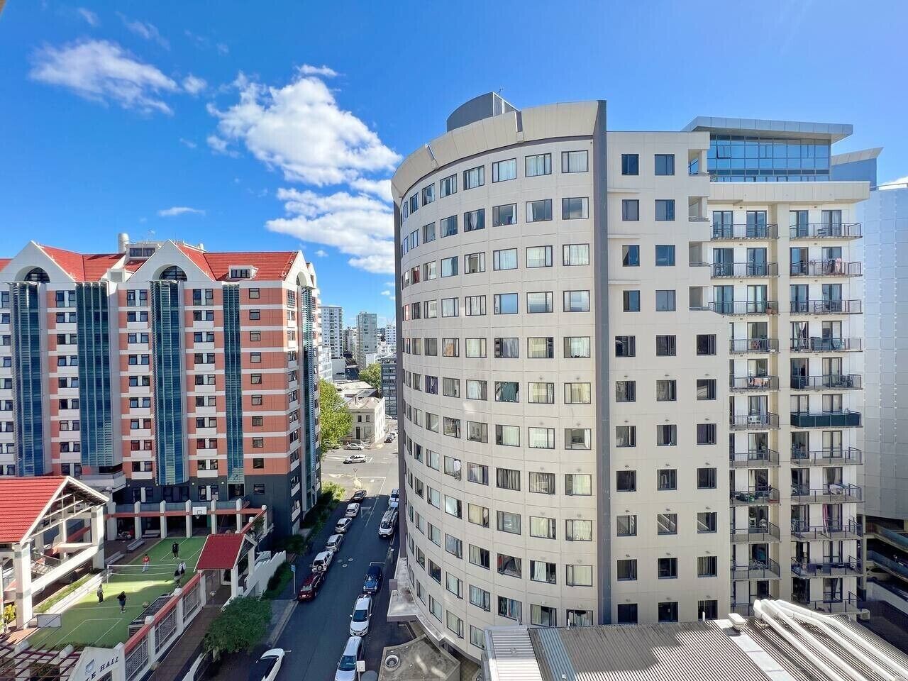 A high-rise building with multiple floors, a curved corner, and a flat roof.
