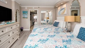 A bedroom with a large bed, a dresser, a TV, and a painting on the wall. - Oceanfront | Amazing Views & Sunrises (Myrtle Beach)