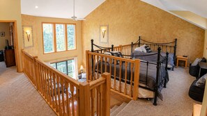 Upstairs loft landing doubles as overflow sleep space, with daybeds tucked behind the spindle railing so kids can crash above while the main floor winds down.
 - Roomy Beautiful Golf/Ski Condo (Clymer)