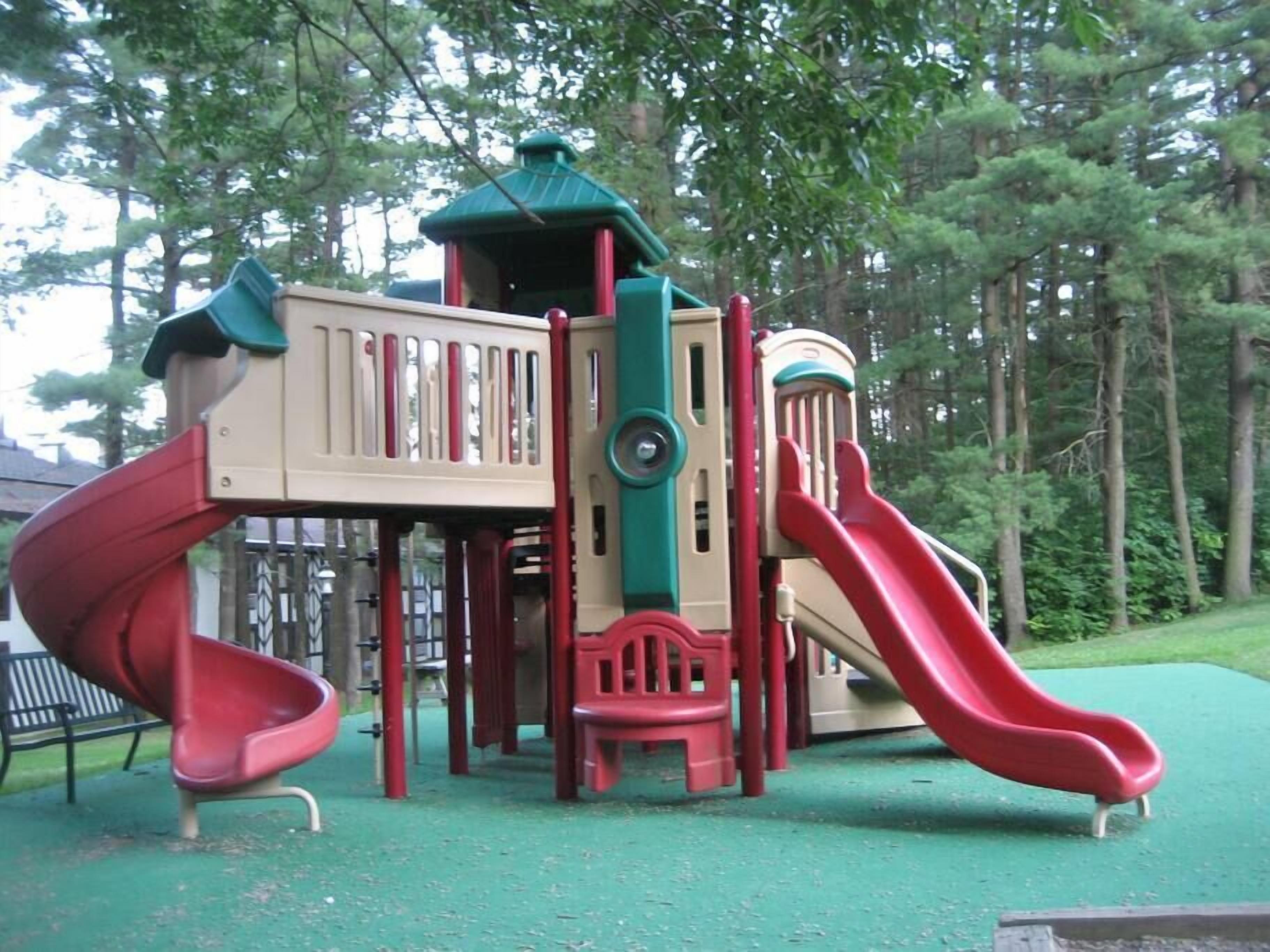 Une aire de jeux avec deux toboggans et une structure d’escalade.