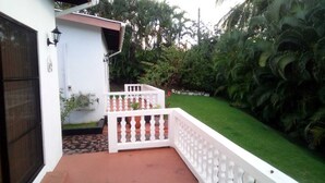 A white building with a red-tiled porch and a white balcony with a balustrade. - Caye Manje Holiday Lodge (Gros Islet)