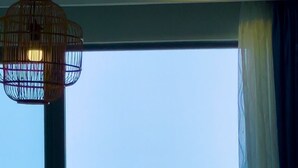 A balcony with a view of the sea, a chair, and a hanging light fixture. - Ocean House in The Song An Gia Vung Tau (Ho Chi Minh City)