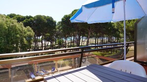 Un balcon donnant sur des arbres et muni d’une balustrade.