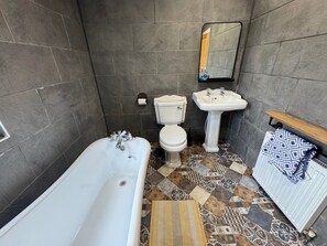 A bathroom with a bathtub, toilet, sink, and a mirror. - 2bed - garden-pets-freeparking-M1connections (Chesterfield)