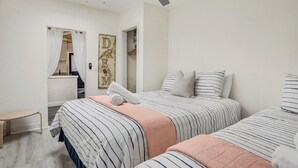 A bedroom with two beds, a ceiling fan, a skylight, a door with curtains, and a wall with a 'DREAM' sign. - Beach Bungalow, Free Parking, 2 blocks to the beach (San Diego)