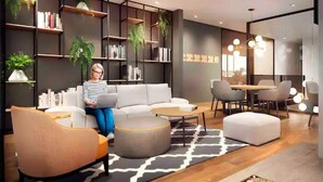 Una sala de estar moderna con sofá, reposapiés y una mesa de centro, rodeada de estanterías y plantas en macetas.