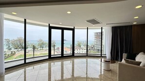 Suite – deluxe | Oppholdsområde | En 65-tommers Flatskjerm-TV med kabel-kanaler samt TV og peis