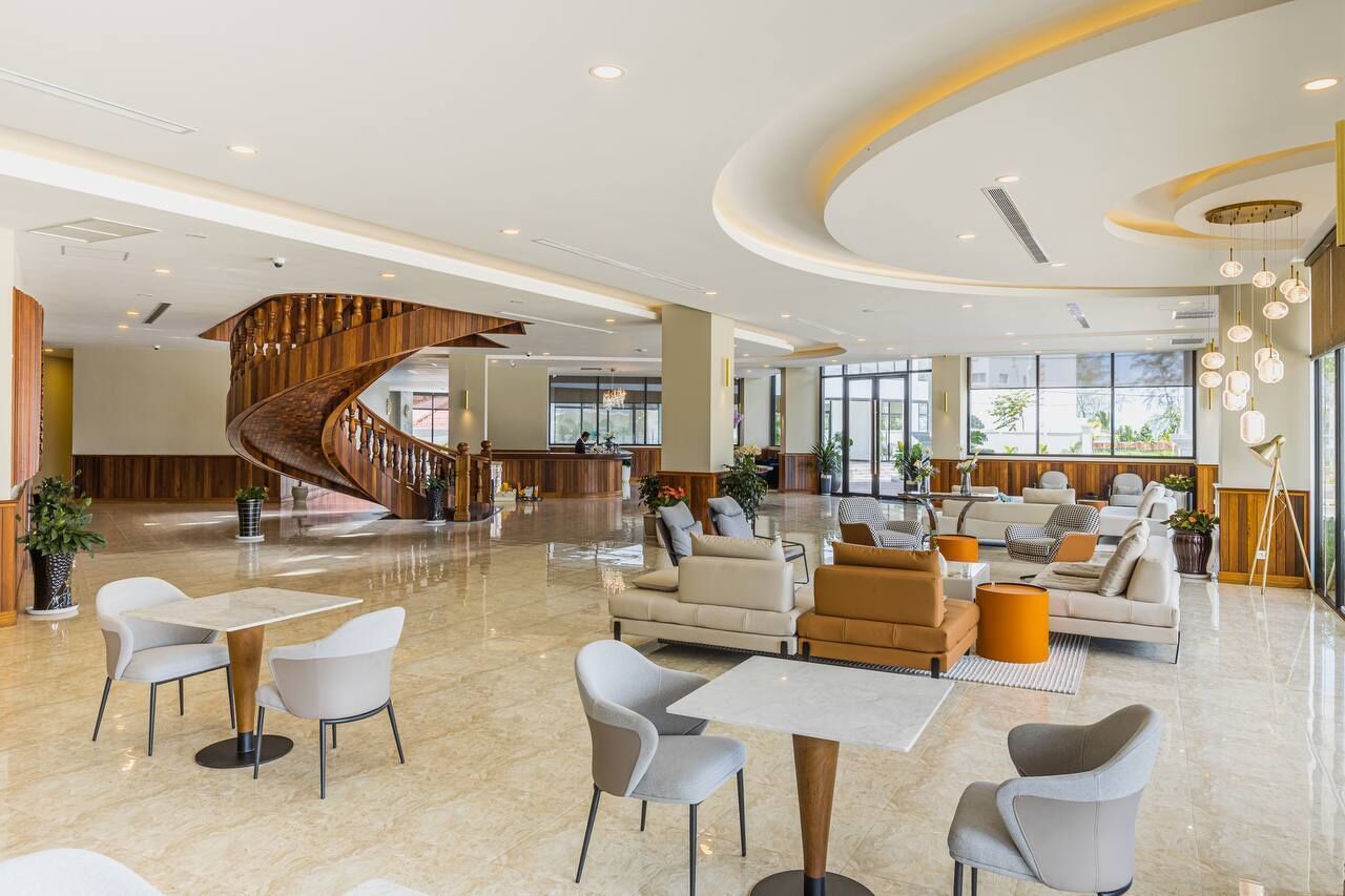 A spacious lobby with a central spiral staircase, modern seating areas, and large windows providing natural light.