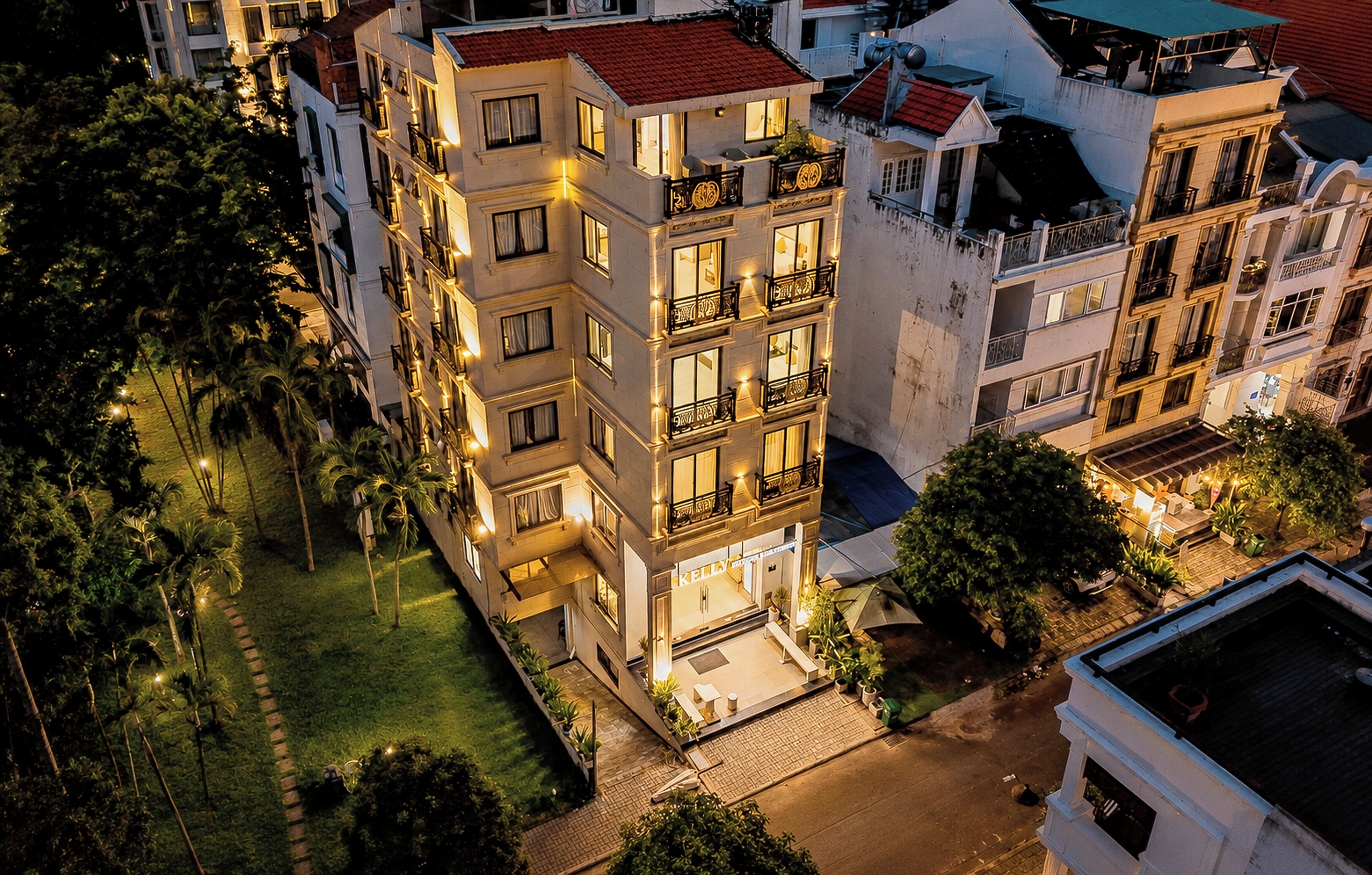 A multi-story hotel with balconies, a courtyard, and a parking area.