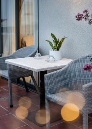 A patio area with wicker furniture and a potted plant. - Kelly Hotel SECC Phu My Hung (Ho Chi Minh City)