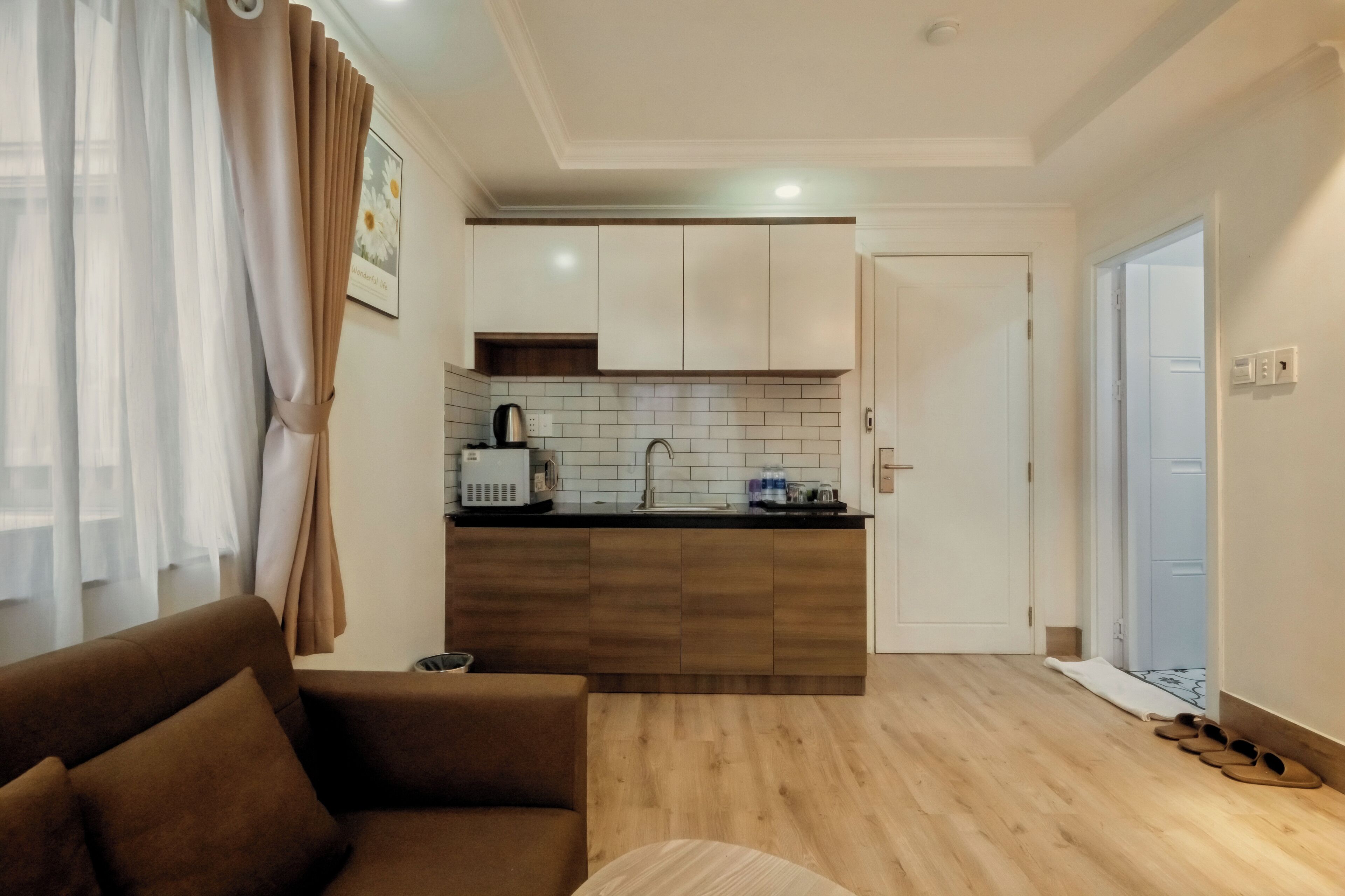 Una sala de estar moderna con un sofá, una mesa de centro y una zona de cocina con alacenas y una encimera.