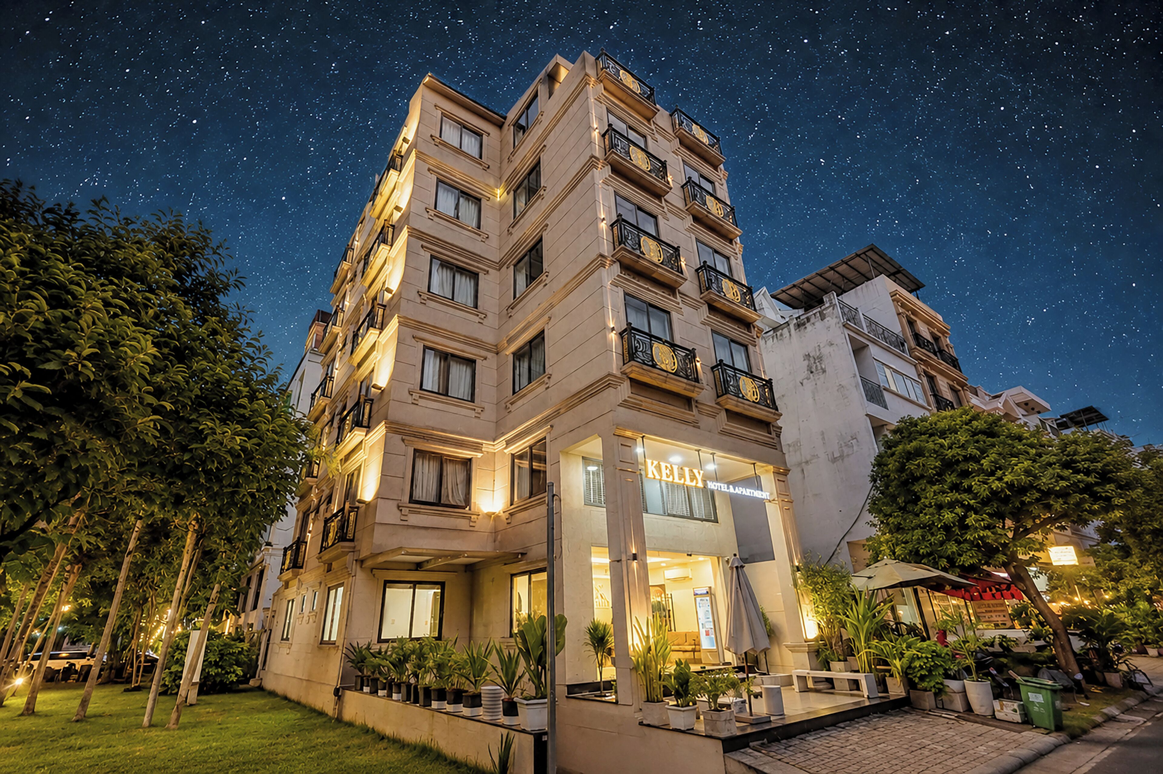 Un hotel con varios pisos, balcones y una entrada bien iluminada.