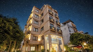 A hotel with multiple floors, balconies, and a well-lit entrance. - Kelly Hotel SECC Phu My Hung (Ho Chi Minh City)
