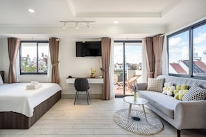 Une chambre d’hôtel moderne équipée d’un lit, d’un canapé, d’un bureau et d’une télévision.