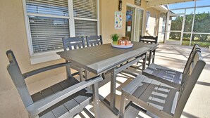 A patio with a wooden table and benches, a potted plant, and a welcome sign. - Near to Disney/ Large Yard/ Private pool/ Quiet Community (Davenport)