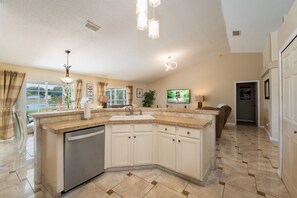 A modern kitchen with a central island, built-in appliances, and a large window offering a view of the outdoors. - Near to Disney/ Large Yard/ Private pool/ Quiet Community (Davenport)