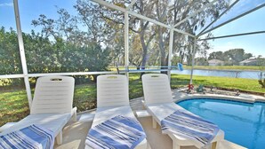A poolside area with white lounge chairs and striped towels. - Near to Disney/ Large Yard/ Private pool/ Quiet Community (Davenport)