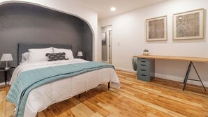 Un dormitorio con una cama, un escritorio y una silla.