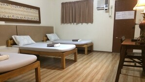 A room with two single beds, a wooden table, and a chair. - CRISFILS LODGE INCORPORATED (Dumaguete)