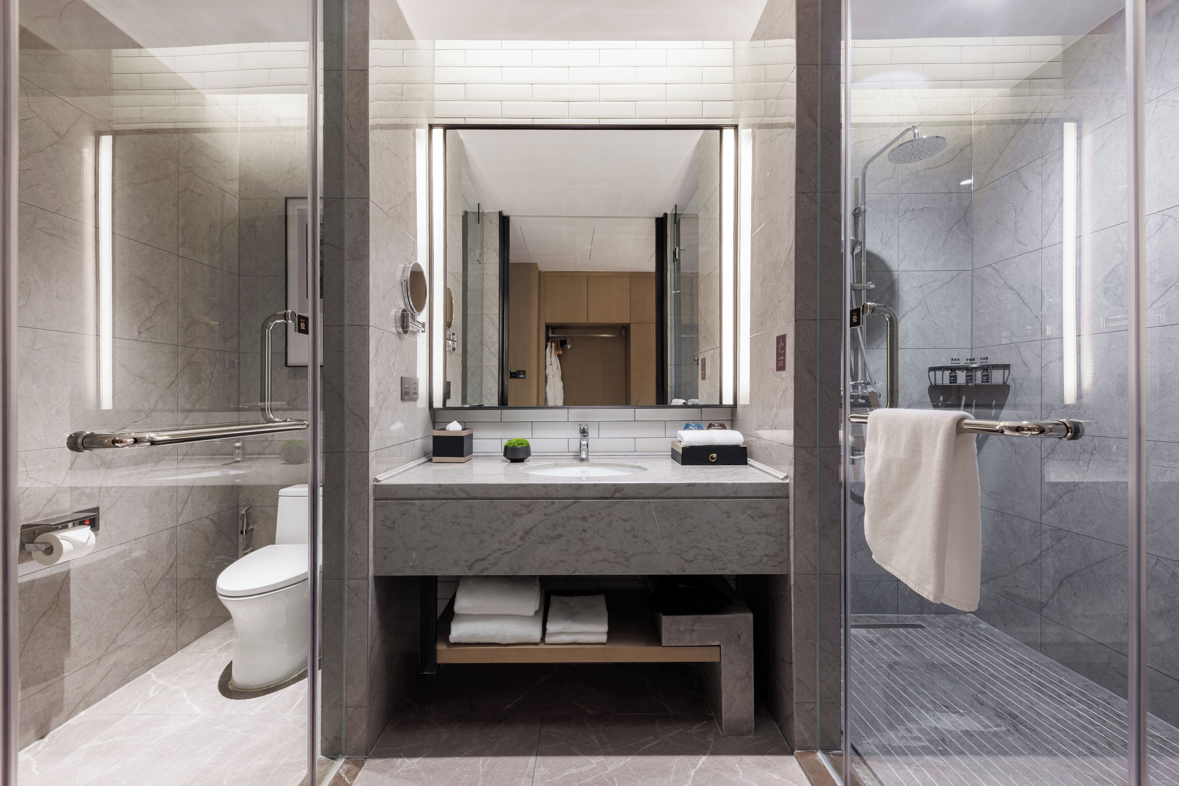Une salle de bain moderne avec une douche à parois de verre, des toilettes et un lavabo avec un miroir au-dessus.