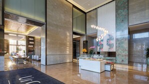 Una hall moderna con reception, area salotto e un’ampia parete decorativa.