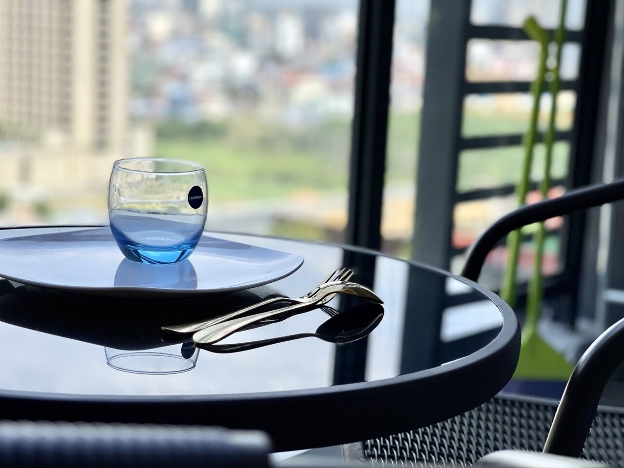 A table with a glass of water, a plate, and cutlery.