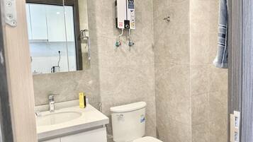 A bathroom with a toilet, sink, and a water heater mounted on the wall.