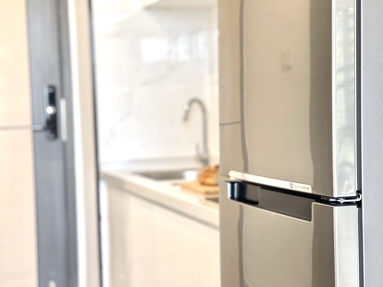Una cocina moderna con un refrigerador de acero inoxidable y un horno empotrado.