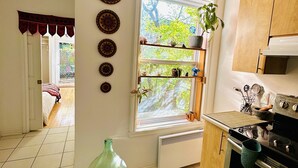 Una cocina con ventana, radiador y estufa.