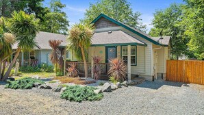 A single-story house with a gabled roof, a front porch, and a fenced backyard. - Single Level Coastal Bungalow, Hot Tub, Pet Friendly, Fire Pit, Moments to Beach and Rockaway (Rockaway Beach)